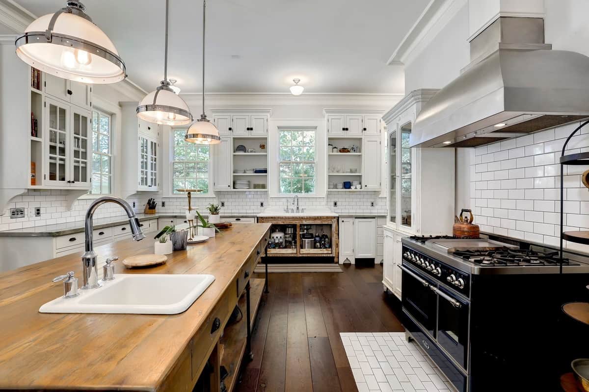 organized high-end kitchen with white cabinetry and wood floor